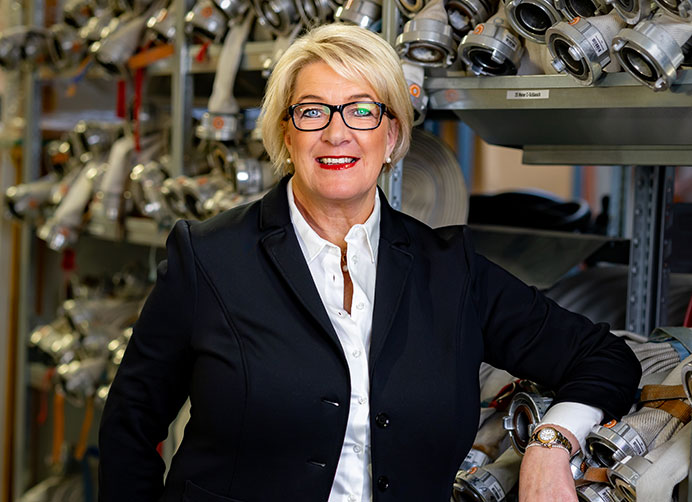Nicole Maack vor einem Regal mit Brandschutzprodukten